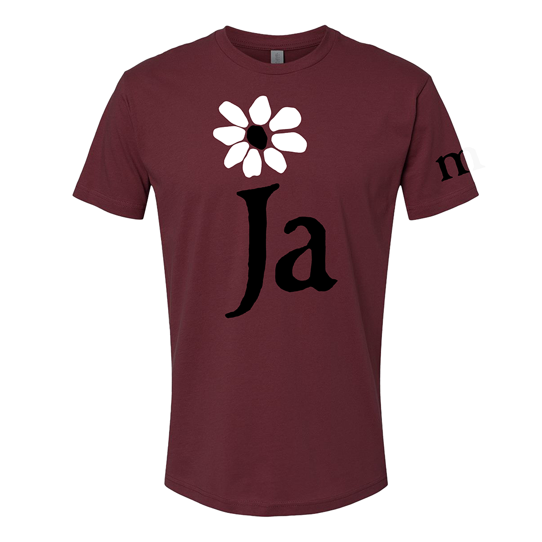 Maroon t-shirt with a white flower and black 'Ja' text on a white background